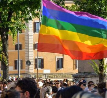 People holding a big Rainbow flag
