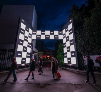 esposizione di milano Design Week di notte cone le persone che camminano davanti