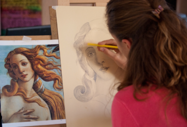 the image demonstrates the young woman taking part in an art course, drawing from Botticelli's Birth of Venus